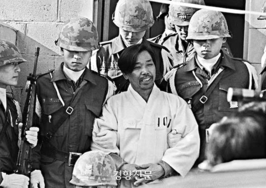 1979년 10월26일 밤 박정희 당시 대통령에게 총을 쏴 살해한 김재규 전 중앙정보부장이 그해 12월20일 육군본부 계엄 보통군법회의(재판장 김영선 중장)에서 선고를 받기 위해 포승에 묶인 채 걸어오며 웃고 있다. 경향신문 자료사진