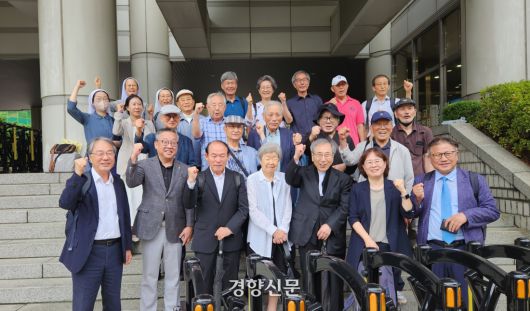 ‘10·26 사건’으로 사형당한 김재규 전 중앙정보부장의 형사재판 재심 첫 공판기일이 열린 16일 서울 서초구 법원종합청사 앞에서 김 전 부장의 여동생 김정숙씨(앞줄 가운데)와 변호인들이 기념 촬영을 하고 있다. 이들은 “지난해 윤석열 전 대통령이 선포한 12·3 비상계엄의 여파인 경찰 저지선도 함께 사진에 나와야 한다”며 경찰 저지선 뒤에 자리를 잡고 섰다. 김정화 기자