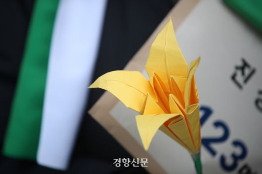 60+기후행동과 기후솔루션 회원들이 지난해 3월6일 서울 중구 국가인권위원회 앞에서 노년층 기후피해 국가인권위 진정 기자회견 중 멸종위기종인 붓꽃 종이 모형과 진정서를 들고 있다.  권도현 기자