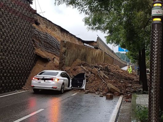 지난 16일 집중호우로 경기 오산 가장교차로 고가도로 옹벽이 붕괴돼 차량 2대가 깔리는 사고가 발생했다. 경기도소방재난본부 제공