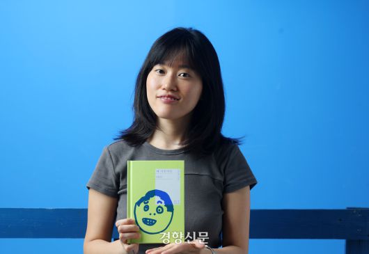 소설 <꽤 낙천적인 아이>의 저자 원소윤씨가 28일 인터뷰에 앞서 경향신문 스튜디오에서 책을 들고 포즈를 취하고 있다. 정지윤 선임기자