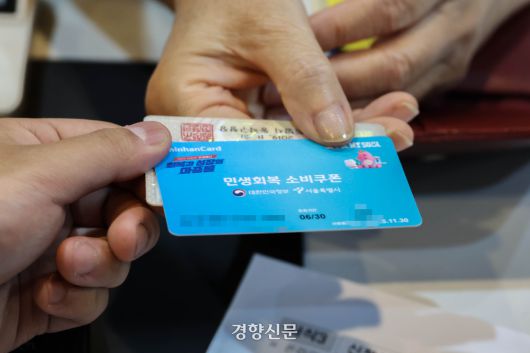 지난 7월 21일 서울 동작구 대방동 주민센터에서 주민들이 민생회복 소비쿠폰 선불카드를 받고 있다. 성동훈 기자