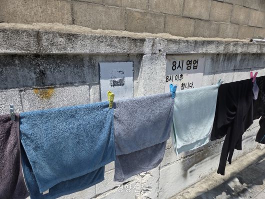 지난 8일 오후 1시쯤 서울 영등포역 인근 ‘유리문 방’ 거리에 ‘8시 이후 영업한다’는 안내문 아래 빨래가 널려있다. 우혜림 기자