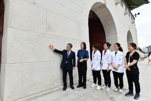 허민 국가유산청장(맨 왼쪽)이 지난 11일 서울 경복궁광화문 석축에서 낙서 제거 작업이 완료된 현장을 국립고궁박물관 유물과학과 보존처리팀 관계자들과 확인하고 있다.   국가유산청 제공