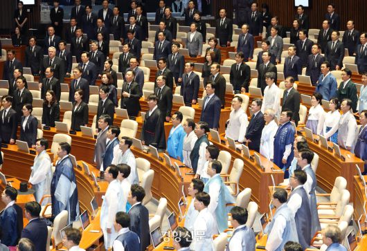 정기국회 개회식이 열린 1일 본회의장에 더불어민주당 의원들은 한복을, 국민의힘 의원들은 검정양복에 근조 리본을 착용한 채 국민의례를 하고 있다. 2025.9.1 박민규 선임기자