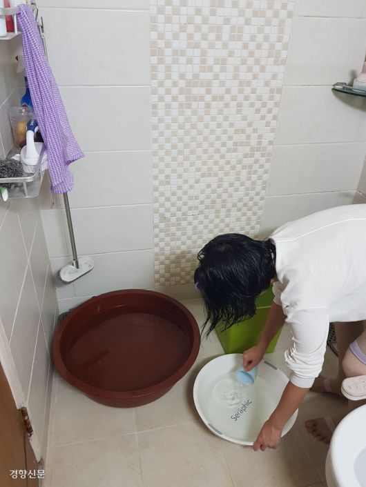 한 시민이 7일 강원 강릉시 내곡동의 한 아파트 욕실에서 미리 대야에 담아둔 물을 뜨고 있다.