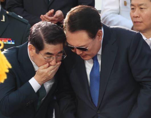 지난해 10월1일 서울 광화문에서 열린 제76주년 국군의 날 시가행진 행사에서 윤석열 전 대통령이 김용현 전 국방부 장관의 이야기를 듣고  있다. 대통령실사진기자단