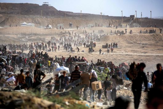 팔레스타인 주민들이 30일(현지시간) 가자 인도재단(GHF)이 운영하는 배급소에서 수령한 구호품을 들고 이동하고 있다. AFP연합뉴스