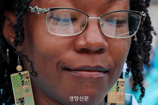 9일 서울 광화문 광장에서 열린 한글 휘호 대회에 참여한 미국인 하디야 씨의 안경에 ‘꽃피우자 아름다운 (한글)’이 비치고 있다. 2025.10.9 이준헌 기자