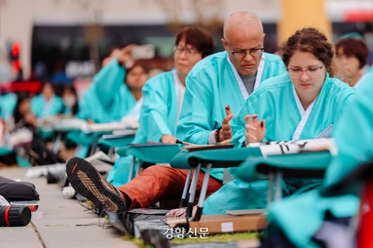 579돌 한글날인 9일 서울 광화문 광장에서 열린 한글 휘호 대회에 참여한 한 외국인이 양반다리 자세를 어려워하고 있다. 2025.10.9 이준헌 기자