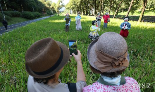 16일 서울 강남구 양재천 벼농사학습장에서 시민들이 허수아비를 사진으로 담고 있다. 성동훈 기자