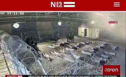 지난해 8월 7일(현지시간) 이스라엘 채널12 뉴스가 보도한 스데 테이만 수용소 내부가 찍힌 영상에서 이스라엘 군인들이 엎드린 수감자들 사이에서 피해자를 끌어내고 있다. 채널12 뉴스 캡처