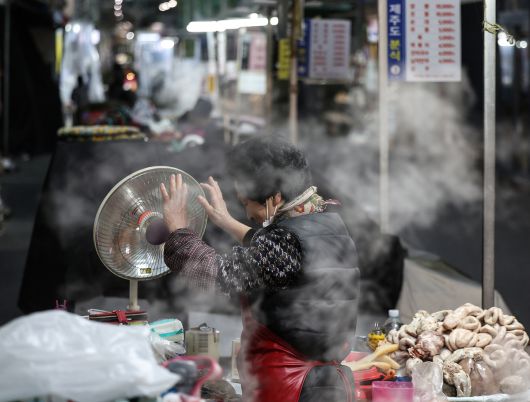 3일 대구 중구 서문시장에서 한 상인이 장사 준비를 하며 빨갛게 언 손을 난방기에 녹이고 있다. 연합뉴스