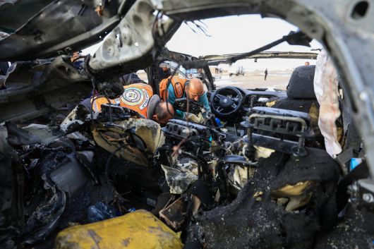 팔레스타인 사람들이 13일(현지시간) 가자시티에서 이스라엘군의 공습으로 자동차가 파괴된 현장을 살펴보고 있다. 로이터연합뉴스