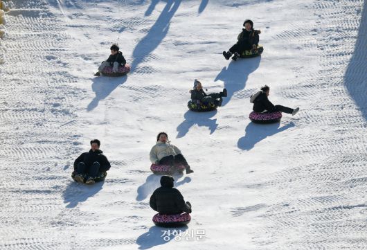 성탄절인 25일 서울 노원구 서울과학기술대학교 종합운동장에 마련된 ‘노원 씽씽 눈썰매장’을 찾은 어린이들과 시민들이 눈썰매를 타고 있다.