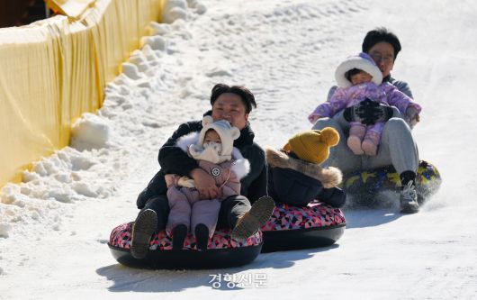 성탄절인 25일 서울 노원구 서울과학기술대학교 종합운동장에 마련된 ‘노원 씽씽 눈썰매장’을 찾은 어린이들과 시민들이 눈썰매를 타고 있다.