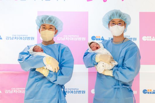 2026년 새해 강남차여성병원에서 태어난 첫 아기 쨈이(왼쪽)와 도리가 각각 아버지인 윤성민씨와 정동규씨 품에 안겨 있다.  강남차여성병원 제공