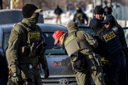 미 국토안보부의 세관국경보호국(CBP) 요원들이 미네소타주 미니애폴리스의 이민세관단속국(ICE) 구금시설 앞에서 팻말을 들고 있던 한 남성을 구금하고 있다. AFP연합뉴스