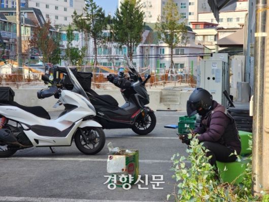 배달노동자들이 2022년 12월 쌍문동의 한 마트 물류창고에서 다음 주문이 올 때까지 대기하고 있다. 강은 기자