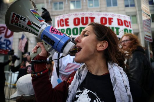 지난 1월 11일(현지시간) 미국 워싱턴 DC의 이민세관단속국(ICE) 본부 밖에서 한 활동가가 구호를 외치며 시위에 참여하고 있다. 최근 미네소타주 미니애폴리스에서 발생한 ICE 요원의 르네 니콜 굿 총격 사망 사건과 트럼프 행정부의 베네수엘라 관련 조치에 반발하는 시위가 전역으로 확산하고 있다. AFP연합뉴스