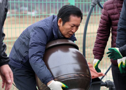 정청래 더불어민주당 대표가 14일 충남 당진시 백석올미마을에서 장독을 옮기고 있다. 연합뉴스