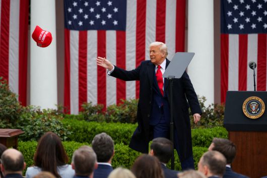 지난해 4월2일 미국 워싱턴 백악관에서 도널드 트럼프 미국 대통령이 연설하던 중  마가(MAGA·미국을 다시 위대하게) 모자를 잡으려 하고 있다. 로이터연합뉴스