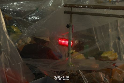 한파가 연일 이어지고 있는 21일 서울 서대문구 인왕시장에서 상인이 전기 난방기구로 추위를 녹이고 있다. 2026.01.21 문재원 기자