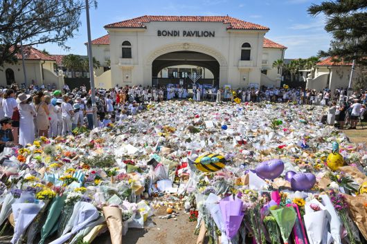 지난달 21일 현지시간) 호주 시드니 본다이 비치에서 시민들이 희생자들을 추모하며 헌화하고 있다. 14일 본다이 비치에서 열린 유대인 공동체의 하누카 축제 행사 도중 발생한 총기 테러로 15명이 희생됐다. EPA연합뉴스