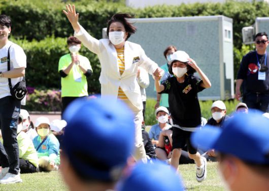 이날만은 동심으로 돌아가 - 문재인 대통령 부인 김정숙 여사가 어린이날인 5일 오후 청와대  녹지원에서  열린  ‘어린이날 100주년 기념 청와대 어린이 초청행사’에서 공굴리기 첫번째 경기에서 승리한 뒤 어린이의 손을 잡고 사회자에게 달려가고 있다.이날 행사에는 벽지 분교 및 개교 100주년을 맞은 초등학교 학생들이 초청됐다. 2022.5.5.연합뉴스