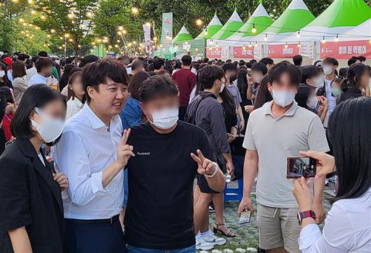 이준석 전 대표가 지난 27일 대구 북구 고성동 DGB대구은행파크 중앙광장에서 열린 ‘2022 대구 북구 떡볶이 페스티벌’ 행사장을 찾아 시민들과 사진을 찍고 있는 모습.대구 뉴스1