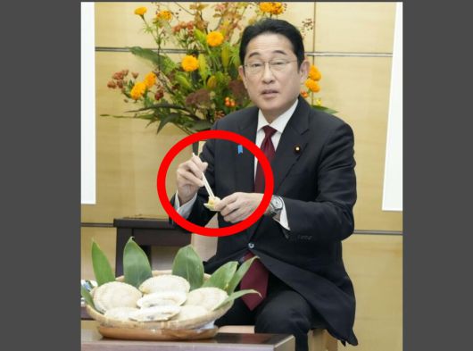 기시다 일본 총리가 17일(현지시간) 도쿄 총리 관저에서 스즈키 나오미치 홋카이도 지사를 만난 자리에서 홋카이도산 가리비회를 시식하고 있다. 교도통신 연합뉴스