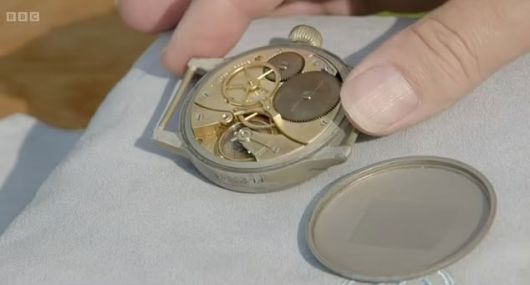 시계 감정사가 한 여성 게스트가 가지고 나온 시계의 뒷판을 열고 무브먼트 등 시계 부품을 살피고 있다. / 사진=BBC
