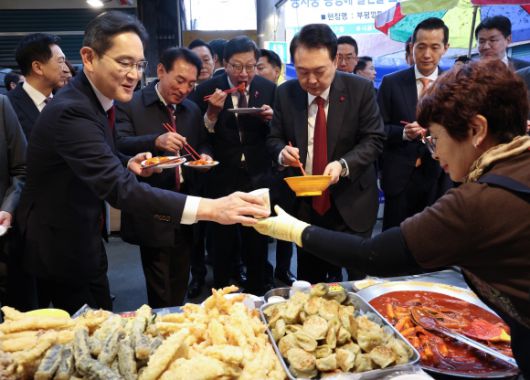 이재용 삼성전자 회장이 6일 부산 중구 깡통시장에서 윤석열 대통령과 함께 분식을 맛보던 중 상인으로 부터 어묵 국물을 받고 있다.  2023.12.6 연합뉴스