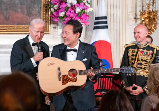 미국을 국빈 방문한 윤석열 대통령이 백악관에서 열린 국빈만찬 특별공연에서 조 바이든 대통령으로부터 ‘아메리칸 파이’를 부른 싱어송라이터 돈 매클린의 친필 서명이 담긴 기타를 선물받고 있다. 서울신문DB