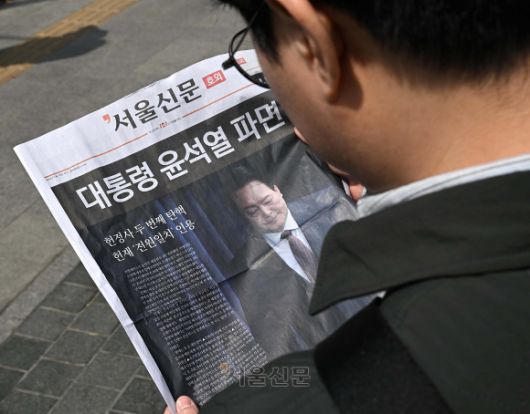 윤석열 대통령이 파면된 4일 오후 서울 중구 시청역 인근에서 시민들이 윤 대통령 파면 관련 서울신문 호외를 읽고 있다. 오장환 기자