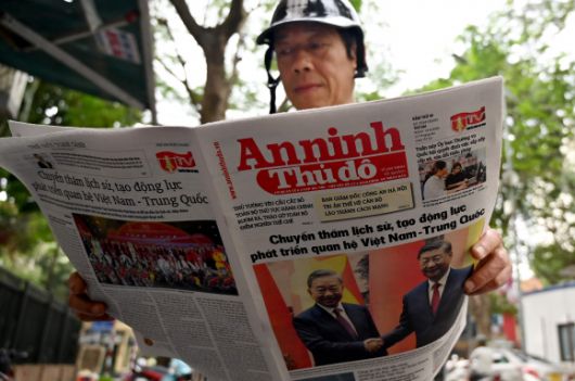 14일 한 베트남 남성이 베트남 공산당 총서기인 또 람(왼쪽)이 중국 시진핑 주석(오른쪽)과 악수하는 사진이 1면에 실린 현지 신문을 읽고 있다. 시 주석은 동남아시아 순방을 시작하며 “보호무역주의는 어디에도 도움이 되지 않는다”며 “무역전쟁은 승자가 없을 것”이라고 경고했다. 하노이 AFP 연합뉴스