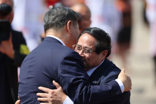 시진핑 중국 국가주석(왼쪽)이 15일 베트남 하노이의 노이바이 국제공항에서 팜 민 친 베트남 총리와 포옹하고 있다. 하노이 AP 연합뉴스