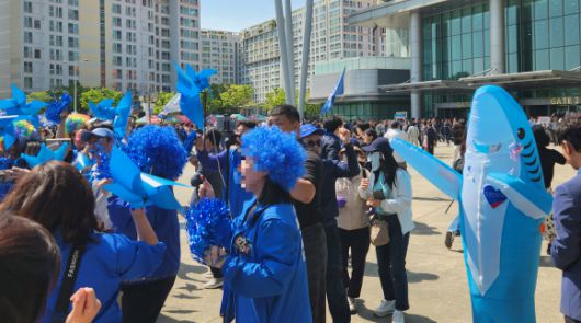 더불어민주당의 21대 대선 후보자 호남권 합동연설회가 열린 26일 전남 광주 김대중컨벤션센터 앞에 옷, 가발, 인형탈, 바람개비 등 각자 파란색 아이템으로 꾸민 민주당 당원들이 춤을 추며 축제 분위기를 즐기고 있다. 광주 곽소영 기자