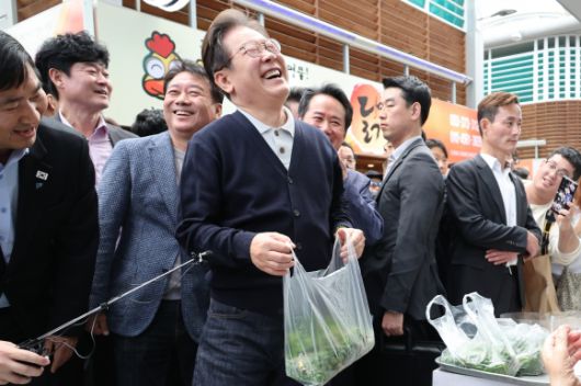 산나물 파는 노인과 대화하며 활짝 웃는 이재명 후보 - 이재명(가운데) 더불어민주당 대선 후보가 ‘골목골목 경청 투어’ : 단양팔경 편‘에 나선 4일 강원도 영월군 영월서부시장에서 산나물을 파는 노인과 대화하며 활짝 웃고 있다.  2025.5.4