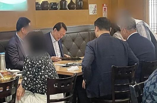 윤석열 전 대통령이 지난달 23일 경기 성남시 판교의 한 보리밥집을 방문했다고 오마이뉴스가 같은 달 28일 보도했다. 사진은 윤 전 대통령이 일행과 식사하기 위해 메뉴판을 들여다보고 있는 모습. 오마이뉴스 제공