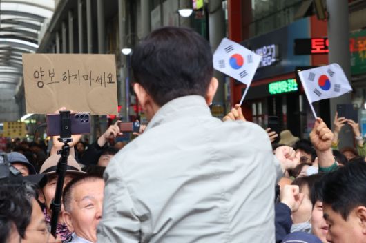 ‘양보하지 마세요’ - 김문수 국민의힘 대선 후보가 6일 경북 포항시 죽도시장을 방문해 시민들에게 인사하고 있다.뒤로 양보하지 마세요란 글자가 보인다. 2025.05.06. 뉴시스