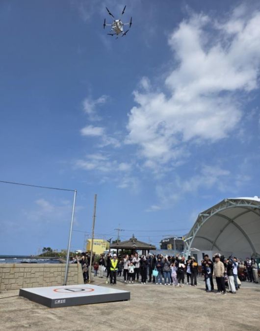 제주도가 올해 첫 드론배송 서비스를 개시하는 기념으로  비양도 주민들이  마련한 쿠키 등 간식을 지난 10일 한림읍 금능해변에서 비양도로 드론 배송하고 있다. 제주도 제공