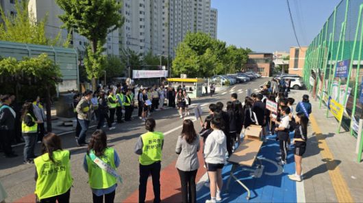 학부모회, 교사, 지역사회 인사들과 함께 참여한 학교폭력·도박 예방 캠페인 현장. 이기환 의원과 관계자들이 도박의 위험성과 예방의 중요성을 알리는 문구가 적힌 피켓과 자료를 학생들에게 나눠주며 인사를 건네고 있다.