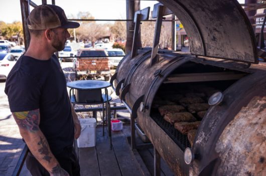 매장 앞에 놓인 바비큐 피트와 피트 마스터의 모습. 피트 안에서 브리스킷이 천천히 요리되고 있다.