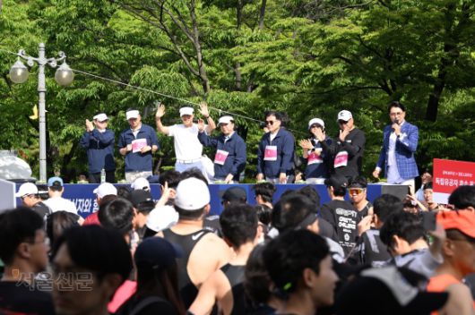 대회에 참석한 김태균(왼쪽부터) 서울신문 콘텐츠본부장, 김성수 서울신문 사장, 오세훈 서울시장, 김철수 대한적십자사 회장, 박용수 인사혁신처 차장, 안미현 서울신문 마케팅본부장, 마라토너 이봉주 선수가 손을 흔들고 있다.  홍윤기 기자