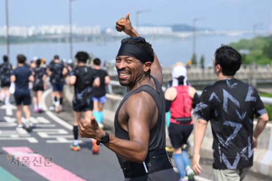 가양대교 위를 달리던 외국인 참가자가 양손 엄지를 치켜든 채 환하게 웃고 있다. 홍윤기 기자