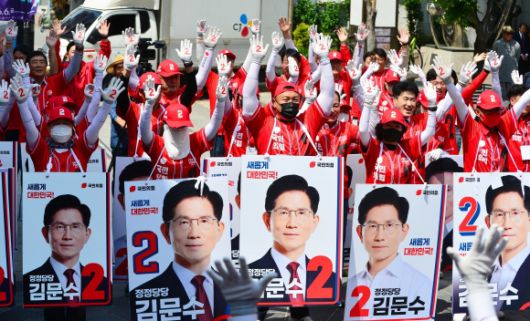 국민의힘 충북도당 선거대책위원회가 지난 13일 충북 청주시 성안길에서 열린 출정식에서 국민의힘의 기호인 ‘2’가 적힌 장갑을 양손에 낀 채 두 팔을 번쩍 치켜들고 있는 모습. 청주 뉴시스