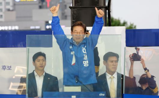 이재명 후보 ‘빼꼼’ - 이재명 더불어민주당 대선후보가 20일 경기 김포시 구래역 문화의 거리에서 열린 유세에서 방탄 유리막 연단에서 사다리에 올라 시민들에게 인사하고 있다. 2025.05.20. 뉴시스