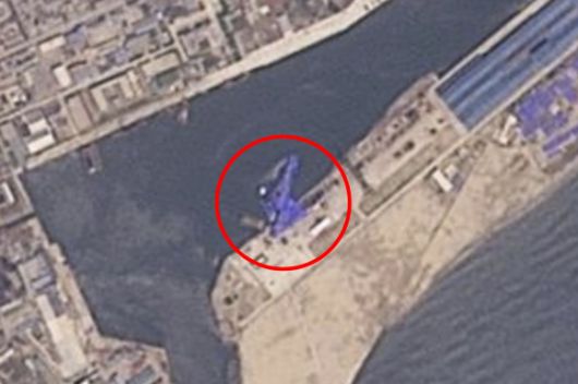 22일 북한 함경북도 청진시 청진항 인근 위성 사진. 전날 진수 과정 중 사고로 바다에 빠진 5000t급 새 구축함이 파란색 방수포로 덮인 채 옆으로 누워 있다. 2025.5.22 플래닛랩스 AP 연합뉴스