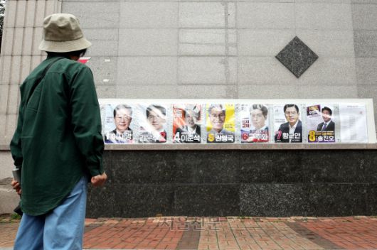 제21대 대통령 선거 벽보 부착 시작된 15일 광주 북구 운암사거리 인근에 붙은 벽보 앞을 시민이 지나가고 있다. 2025.5.15 광주 북구 제공